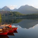 Colorful boats reflecting in the waters of Strbske Pleso Lake along with mountains
