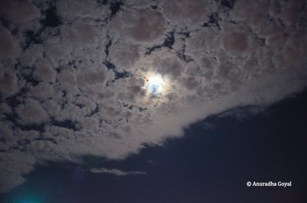 Moon playing hide & seek behind silver colored clouds